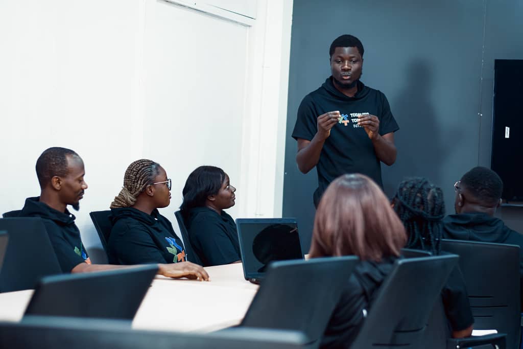 TFT-Today's Skill Hub facilitator leading a team seminar with participants seated around a conference table.